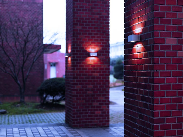 Außenaufnahme von beleuchteten Backsteinsäulen in einem Gartenbereich