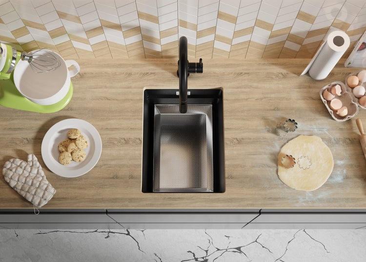 Küchenszene mit Spüle, Armatur, Arbeitsplatte und Küchenutensilien für die Zubereitung von Speisen