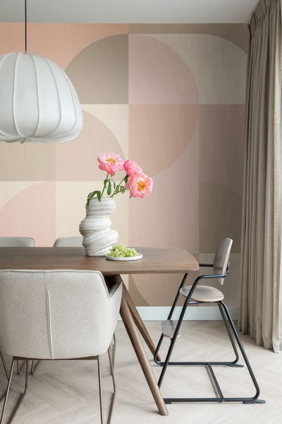 Esszimmer mit Esstisch, Stühlen, Vase mit Blumen und geometrischer Tapete