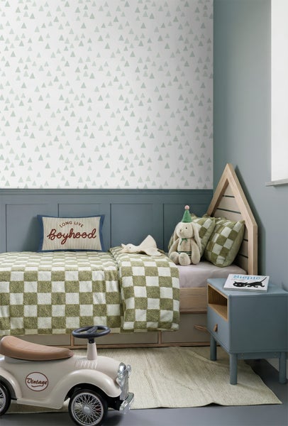 Kinderzimmer mit Hausbett aus Holz, grün karierter Bettwäsche und Tapete mit Dreiecksmuster über einer blauen Wandtäfelung.