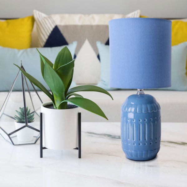 Dekorative Tischszene mit Lampe und Zimmerpflanzen auf einem Tisch