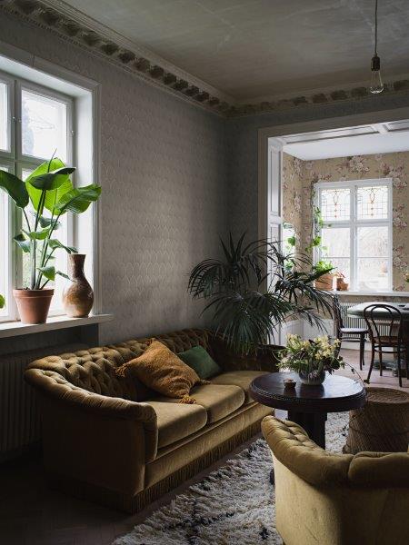 Wohnraum mit gemusterter Tapete, Sofa und Dekorationen für ein stilvolles Interieur