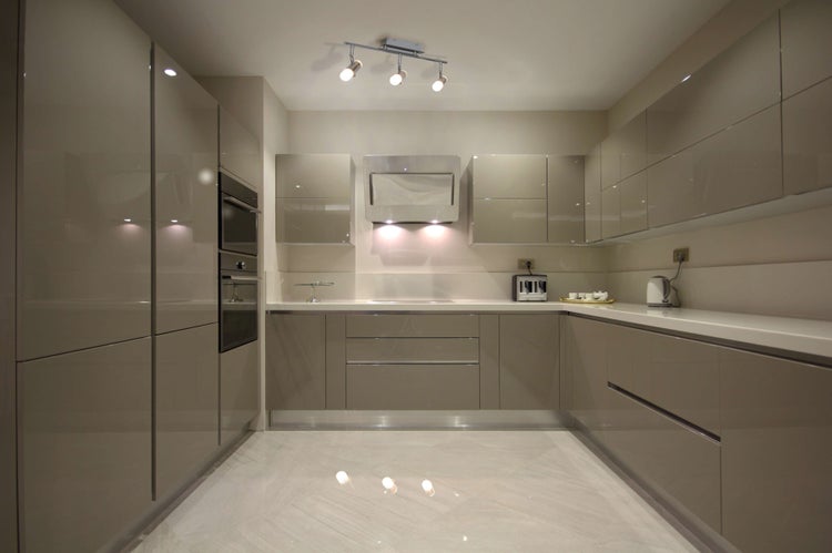 Helle Einbauküche mit Elektrogeräten und Arbeitsfläche.