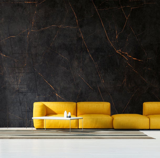 Wohnzimmer mit gelbem Sofa und Wandfliesen in Marmoroptik