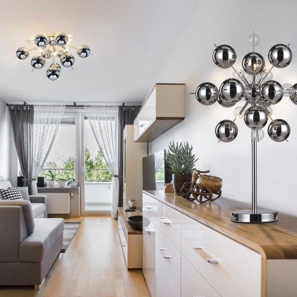 Wohnzimmer mit Sofa, Schrankwand und Kugel-Deckenleuchte sowie Kugel-Tischleuchte