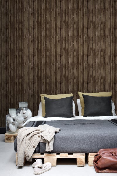 Schlafzimmer mit Holzwandtapete, Bett aus Europaletten und dekorativen Glühbirnen