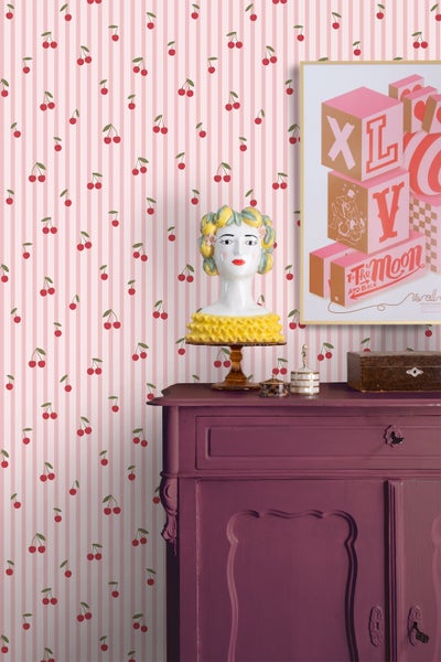 Einrichtungsidee mit gestreifter Tapete und Kirschmuster, antikem Schrank und Dekorationen