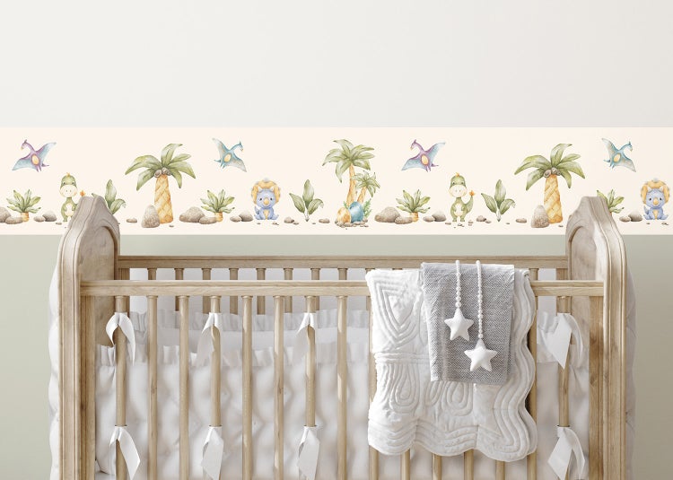 Tapetenbordüre mit Dinosauriern und Palmen im Aquarellstil in einem hellen Kinderzimmer über einem Kinderbett aus Holz.