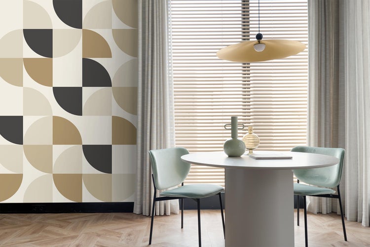 Helles Esszimmer mit geometrischer Tapete, rundem Tisch und Stühlen