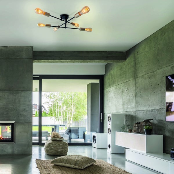 Modernes Wohnzimmer mit Betonwänden, Kamin und einer Deckenleuchte mit mehreren Armen