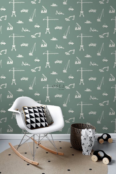 Raumgestaltung mit Kinderzimmer-Tapete, die Baufahrzeuge zeigt, einem Schaukelstuhl, einem runden Teppich und einem Korb.