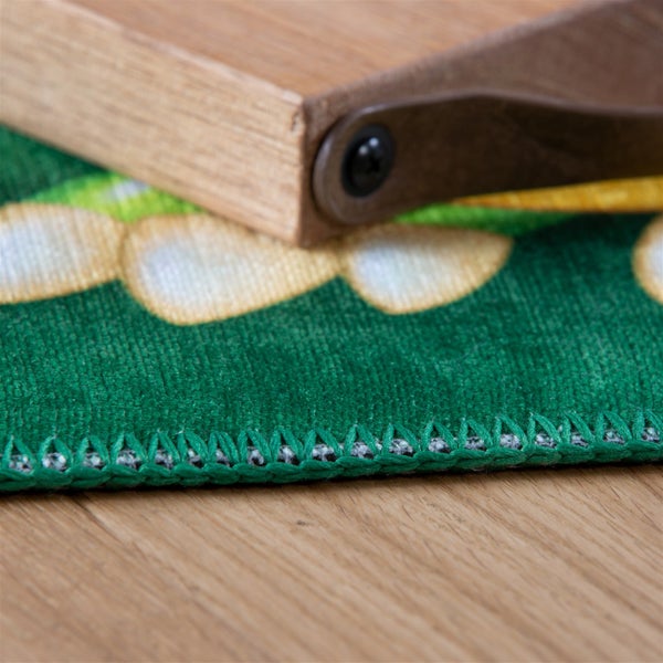 Nahaufnahme eines grünen gemusterten Teppichs mit geketteltem Rand.