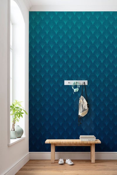 Raumgestaltung mit blau gemusterter Tapete, Holzbank und Dekorationen