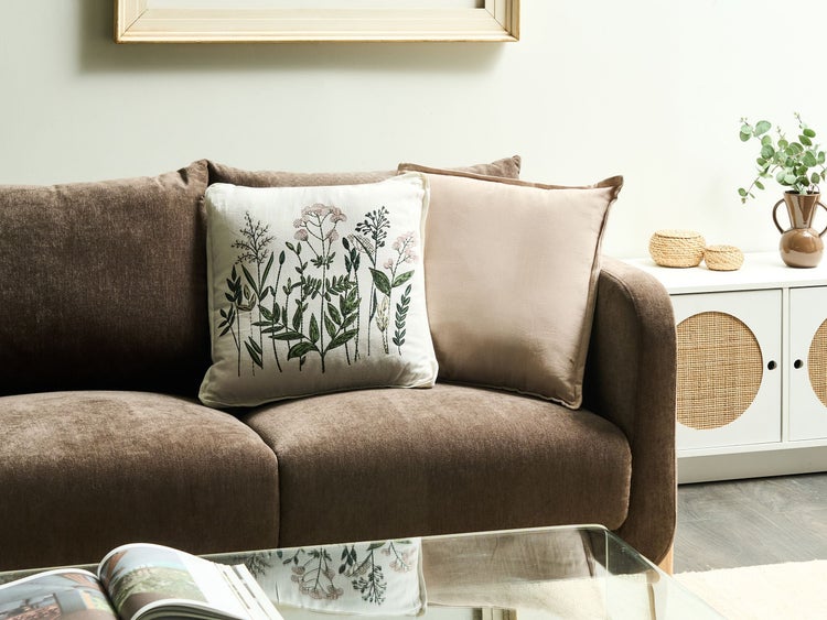 Gemütliche Wohnzene mit braunem Sofa und dekorativen Kissen