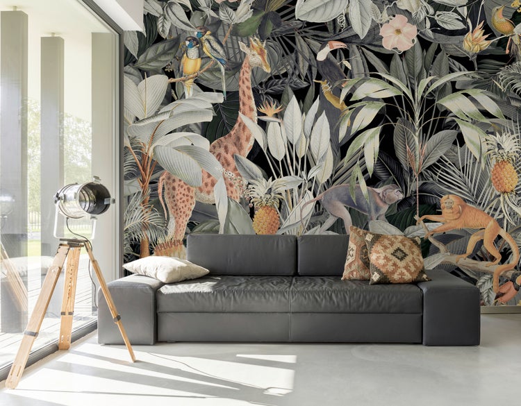 Modernes Wohnzimmer mit großer Dschungel-Tapete mit Giraffe, Affen und tropischen Pflanzen hinter einem dunkelgrauen Ledersofa.