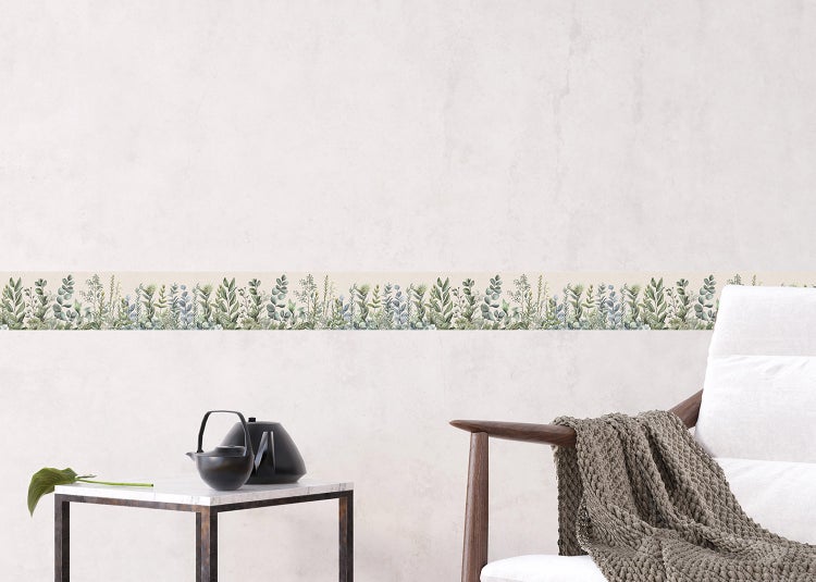 Tapetenbordüre mit botanischem Blättermuster in einem hellen Zimmer über einem Beistelltisch mit Teekanne.