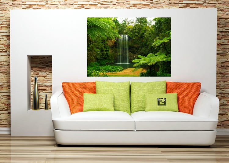 Dekoratives Wohnzimmer mit Sofa, Kissen und Wandbild mit Wasserfallmotiv