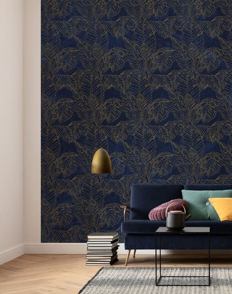Wohnzimmer mit dunkelblauer Tapete und goldenem Blattmuster, Sofa, Tisch und Dekoration