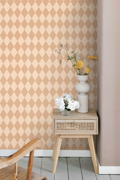 Vliestapete mit Rautenmuster in einem hellen Raum neben einem hölzernen Beistelltisch mit Blumenvasen.