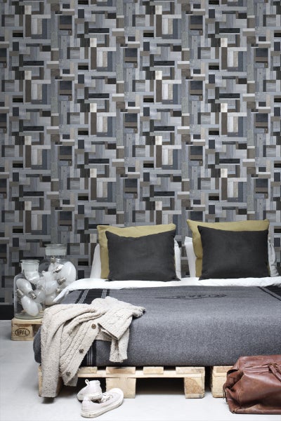 Schlafzimmer mit Holzwandpaneelen im Patchwork-Stil und Bett auf Holzpaletten