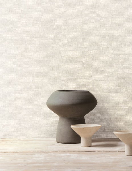 Nahaufnahme einer strukturierten Tapete mit zwei Vasen auf einem Tisch.