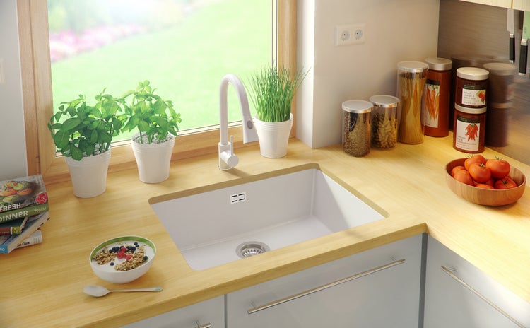 Helle Küche mit Spüle, Armatur, Dekoration und Lebensmitteln auf der Arbeitsplatte