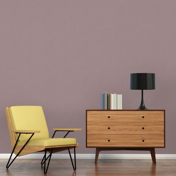 Schreibtisch mit Lampe, Stuhl und Dekor vor einer Wand mit Kreismuster-Tapete.