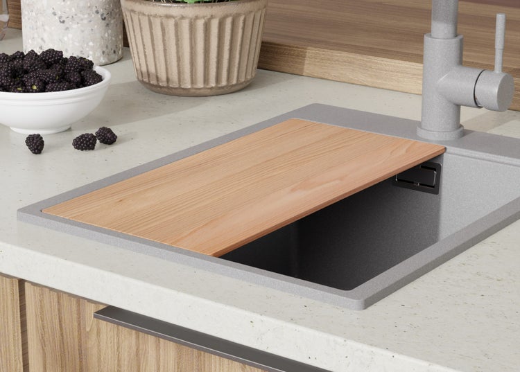 Küchenspüle mit Holzschneidebrett, Armatur und Schale mit Brombeeren