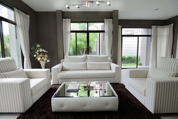 Heller Wohnraum mit Sofa, Sesseln und Couchtisch