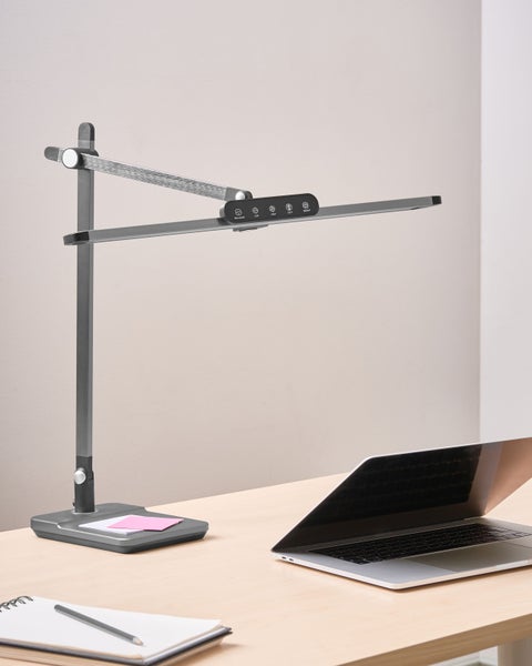 Schreibtisch mit LED-Tischleuchte, Notizblock und Laptop
