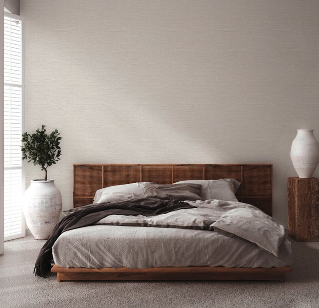 Helles Zimmer mit Holzmöbeln und verschiedenen Tapetenmustern am unteren Bildrand