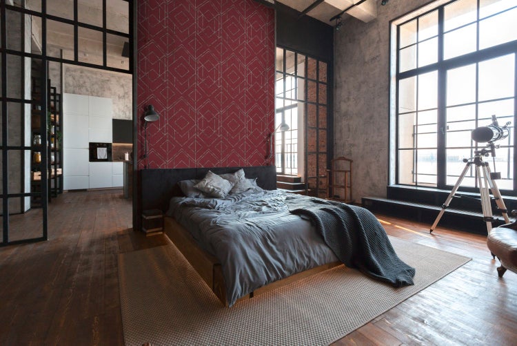 Schlafzimmer im Loft-Stil mit geometrischer Tapete, Bett und großen Fenstern