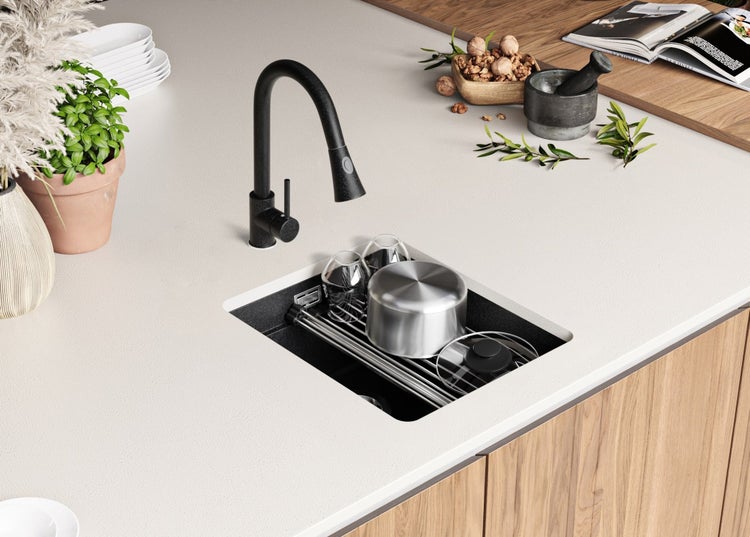 Küchenspüle mit schwarzer Armatur und Spülbecken mit Abtropfgestell auf einer Arbeitsplatte