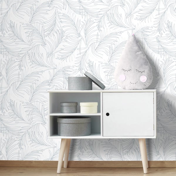 Vliestapete mit grauem, filigranem Blattmuster auf weißem Grund in einem hellen Raum mit weißem Sideboard und Holzfußboden.