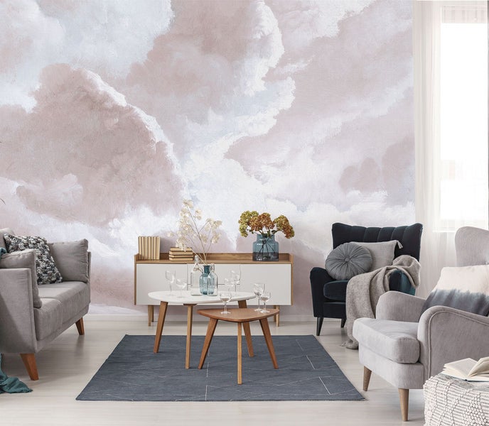 Wohnzimmer mit Sofa, Sesseln, Couchtischen und einer Wand mit Wolkenmotiv
