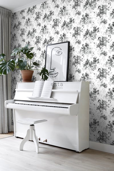 Zimmer mit weißem Klavier, Hocker, Zimmerpflanze und Tapete mit Blumenmuster