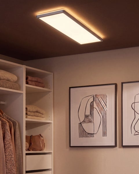 Rechteckige LED Deckenleuchte in einem modern eingerichteten Ankleidezimmer mit Regal und gerahmten Wandbildern