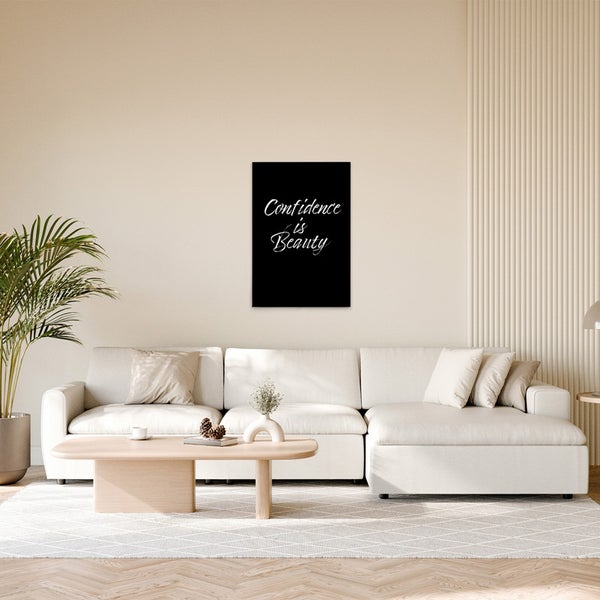 Wohnzimmer mit Sofa, Tisch und gerahmtem Bild mit der Aufschrift Confidence is Beauty