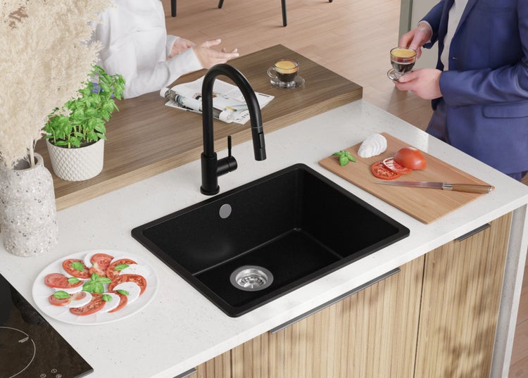 Schwarzes Küchenspülbecken mit Armatur in einer hellen Küche.