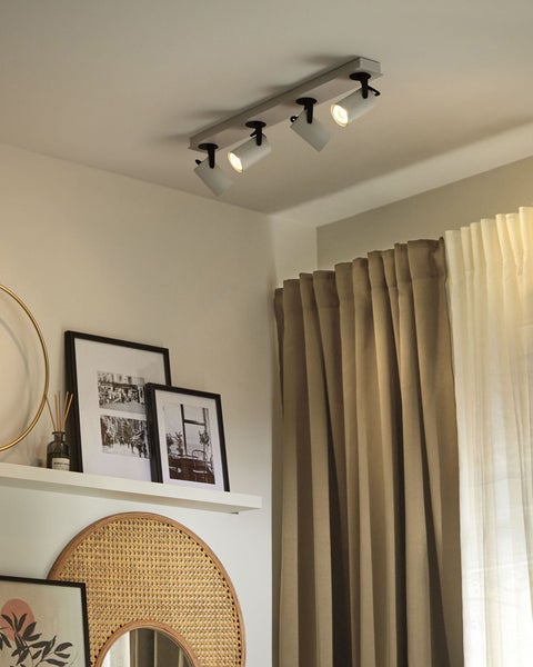 Dipladenia-Pflanzen mit grünen Blättern und weißen Knospen in beigefarbenen Pflanztöpfen mit Rio Dipladenia Etiketten.