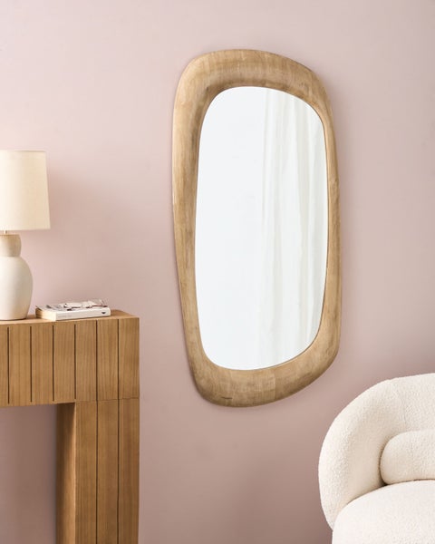 Dekoratives Wandspiegel mit Holzrahmen über einem Konsolentisch