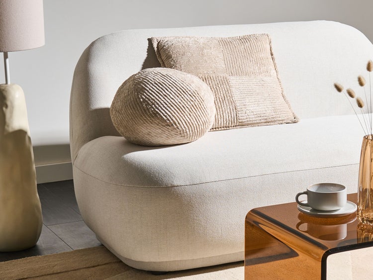 Szene mit Sofa, Kissen, Tischlampe und Dekoration