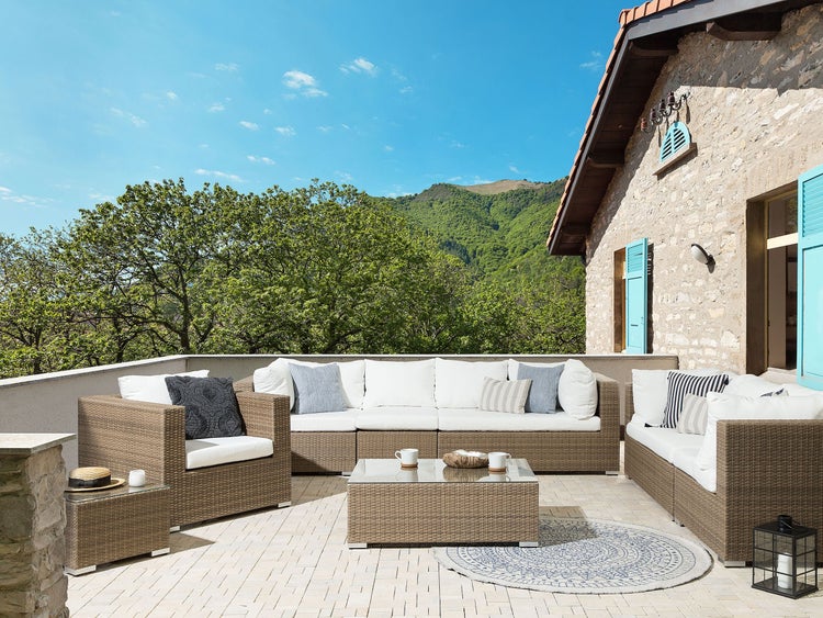 Gartensitzgruppe mit Rattansessel, Sofa und Tisch auf einer Terrasse