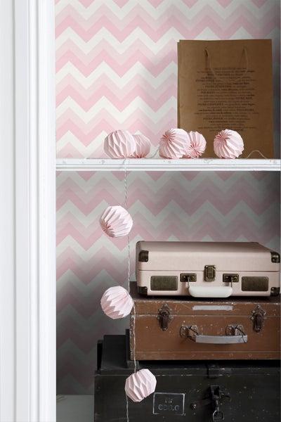 Dekoratives Regal mit Tapete mit Zickzackmuster, beleuchteten Papierkugeln und Vintage-Koffern