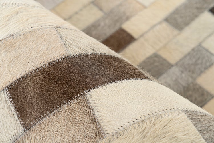 Patchwork-Teppich aus echtem Kuhfell mit Zickzack-Nähten und geometrischem Muster.