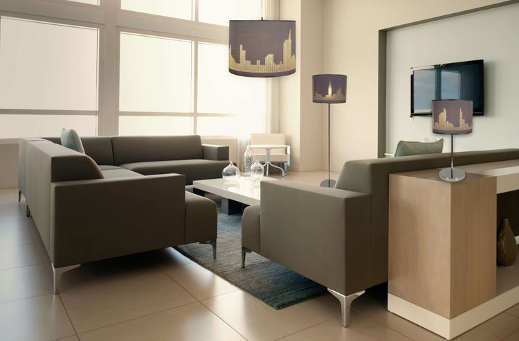 Helles Wohnzimmer mit Sofa, Couchtisch und Lampen mit Skyline-Motiv