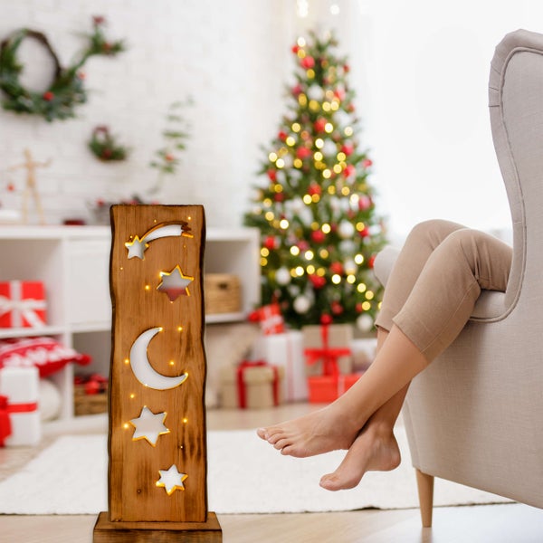 Dekorative Holzleuchte mit Sternen und Mond im Wohnzimmer mit Weihnachtsbaum