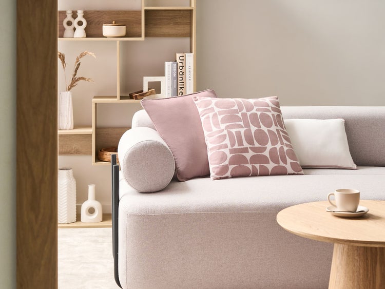 Wohnzimmer-Szene mit Sofa, Kissen, Beistelltisch und Regal