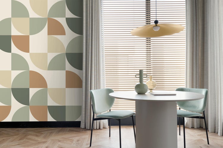 Esszimmer mit geometrischer Tapete, Esstisch, Stühlen und Pendelleuchte.