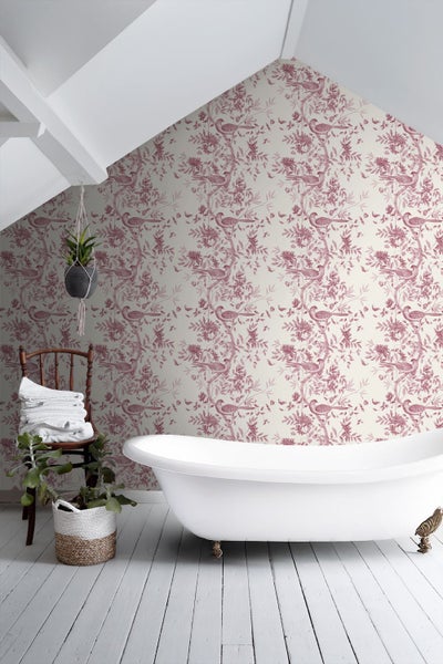 Helles Badezimmer mit freistehender Badewanne und Tapete mit rosa Vogel- und Blumenmuster.